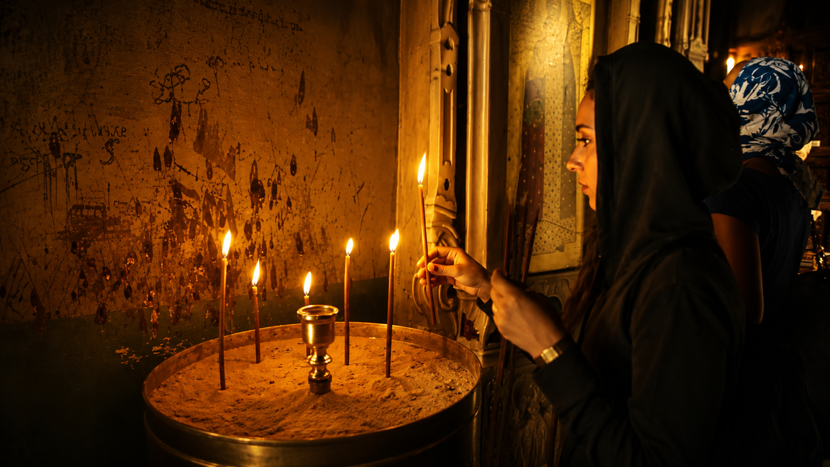 Woman lighting a candle in a sacred interior